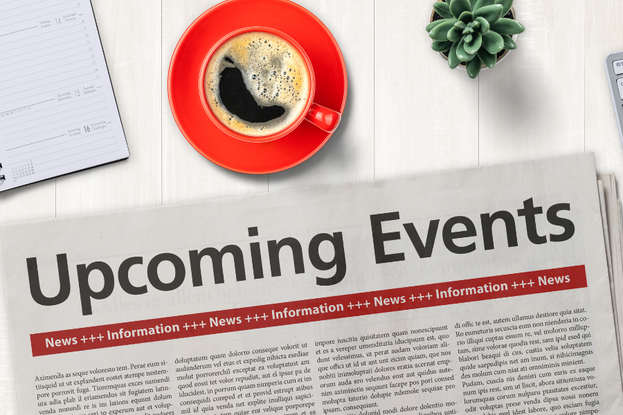 Newspaper with the heading “Upcoming Events” and coffee on a desk